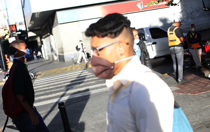 People wearing protective masks on the streets after the start of quarantine in response to the spread of coronavirus disease (COVID-19) in Caracas