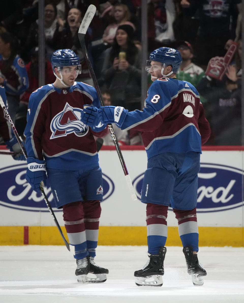 Colorado Avalanche defenseman Cale Makar, right, is congratulated after scoring a goal by defenseman Devon Toews in the second period of an NHL hockey game against the Detroit Red Wings, Monday, Jan. 16, 2023, in Denver. (AP Photo/David Zalubowski)