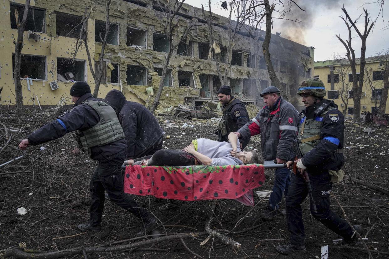Ukrainian emergency employees and volunteers carry an injured pregnant woman from a maternity hospital that was damaged by shelling in Mariupol, Ukraine, March 9, 2022. The woman and her baby died after Russia bombed the maternity hospital where she was meant to give birth. (AP)
