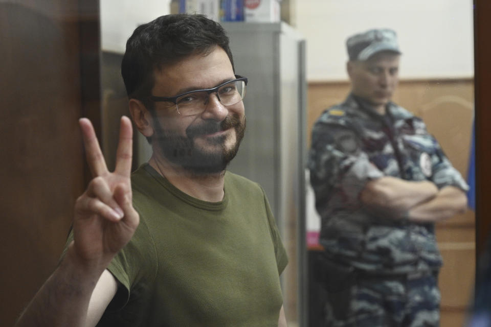 Russian opposition activist and a municipal deputy of the Krasnoselsky district Ilya Yashin stands in a cage at a court room during a hearing on his detention the Basmanny district court in Moscow, Russia, Wednesday, July 13, 2022. Yashin faces charges under a new law making it a crime to spread false information about the military that carry a potential sentence of up to 15 years in prison. (AP Photo/Dmitry Serebryakov)