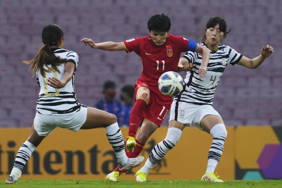 FILE - China's Wang Shanshan tries to tackle the ball during the AFC Women's Asian Cup 2022 final match between China and South Korea in Mumbai, India, Sunday, Feb. 6, 2022. (AP Photo/Rajanish Kakade, File)