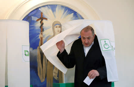 Georgia's President Georgy Margvelashvili leaves a voting booth with his ballot during the second round of parliamentary election in Tbilisi, Georgia, October 30, 2016. REUTERS/David Mdzinarishvili