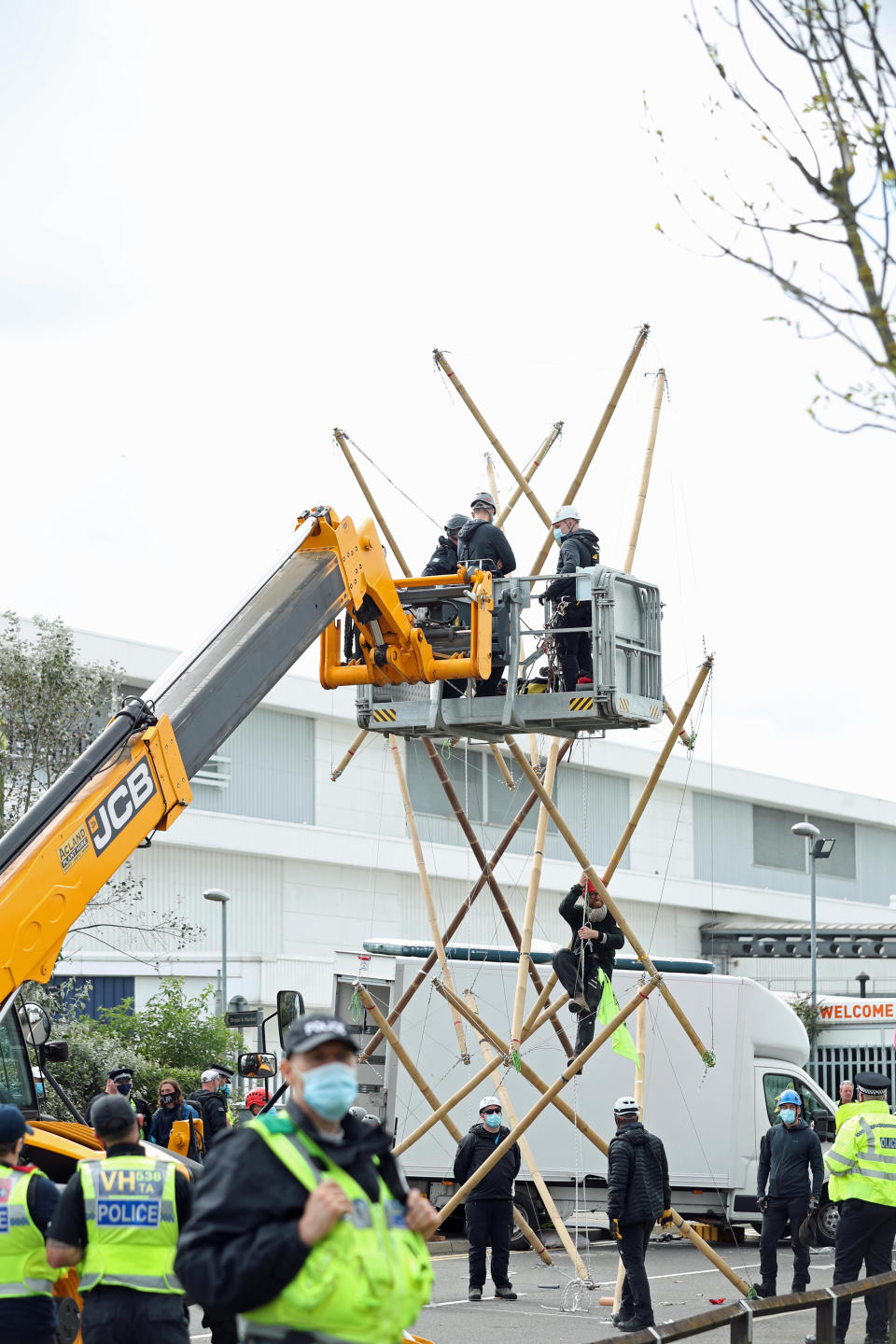 One of the protesters climbs down from the bamboo lock-ons they are using to block the road outside the Newsprinters printing works at Broxbourne, Hertfordshire. (Photo by Yui Mok/PA Images via Getty Images)