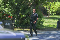 A Charlotte Mecklenburg police officer carries a gun as he walks in the neighborhood where an officer-involved shooting took place in Charlotte, N.C., Monday, April 29, 2024. Police in North Carolina say numerous law enforcement officers conducting a task force operation have been struck by gunfire in Charlotte. (AP Photo/Nell Redmond)