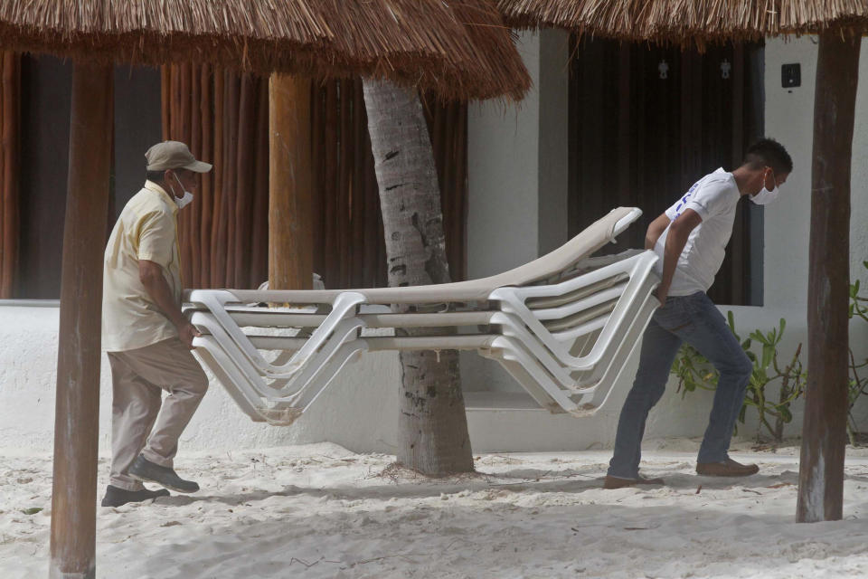 Beach hotel workers store chairs inside as they prepare for the arrival of Tropical Storm Zeta in Playa del Carmen, Mexico, Monday, Oct. 26, 2020. A strengthening Tropical Storm Zeta is expected to become a hurricane Monday as it heads toward the eastern end of Mexico's resort-dotted Yucatan Peninsula and then likely move on for a possible landfall on the central U.S. Gulf Coast at midweek. (AP Photo/Tomas Stargardter)