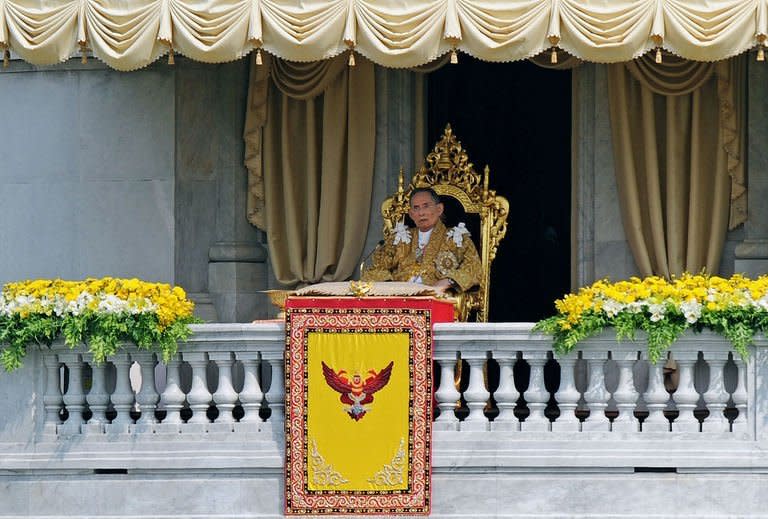 Thai King Bhumibol Adulyadej is shown on the balcony of the Anantasamakom Throne Hall while delivering an address in front of the Royal Plaza in Bangkok on December 5, 2012. Tens of thousands of Thais have crowded central Bangkok for a rare address by the king, the world's longest reigning monarch, as part of celebrations for his 85th birthday