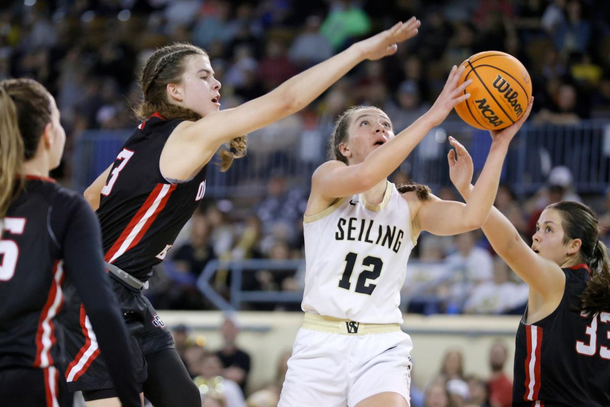 Seiling's Braci Nyberg puts up a shot as Oklahoma Bible Academy's Karson Jenkins, right, and Lilyan Walden defend during the Class A girls state basketball championship game between Seiling and Oklahoma Bible Academy at State Fair Arena in Oklahoma City, Saturday, March 2, 2024.