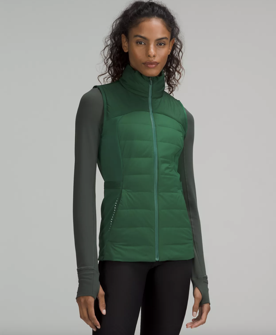 A woman wearing a Down for It All Vest in green. (Photo via Lululemon)