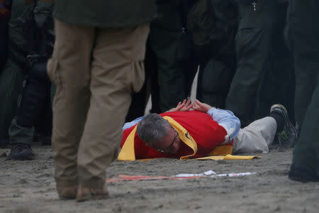 U.S. Customs and Border Protection (CBP) officials detain a man during a gathering in support of the migrant caravan in San Diego, U.S., close to the border wall between the United States and Mexico, as seen from Tijuana, Mexico December 10, 2018. REUTERS/Carlos Garcia Rawlins