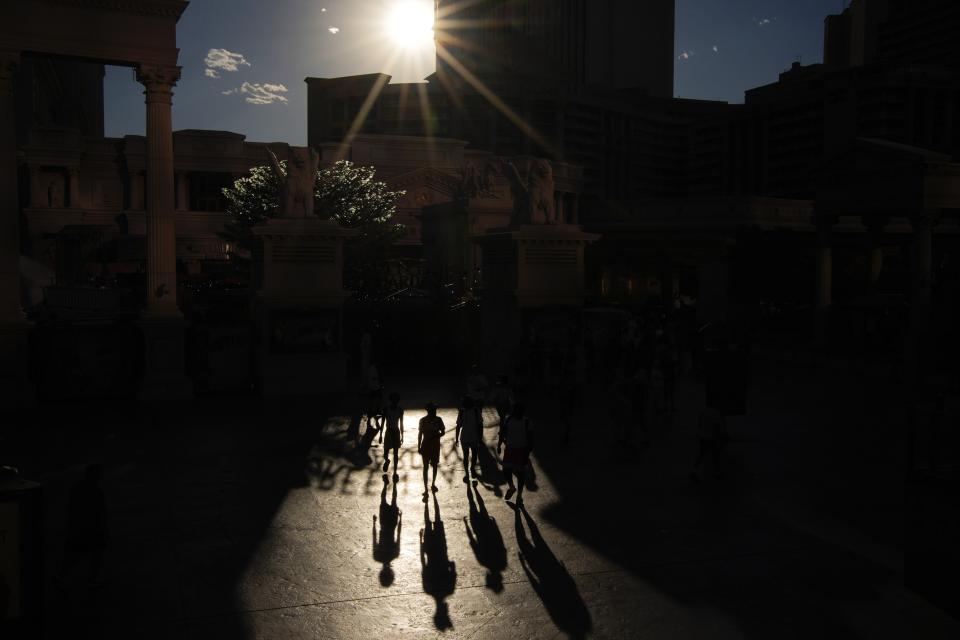 FILE - People walk in the sun along the Las Vegas Strip, Sunday, July 7, 2024, in Las Vegas. Used to shrugging off the heat, Las Vegas residents are now eyeing the thermometer as the desert city is on track Wednesday to set a record for the most consecutive days over 115 degrees (46.1 C) amid a lingering hot spell that's expected to continue scorching much of the U.S. into the weekend. (AP Photo/John Locher, File)