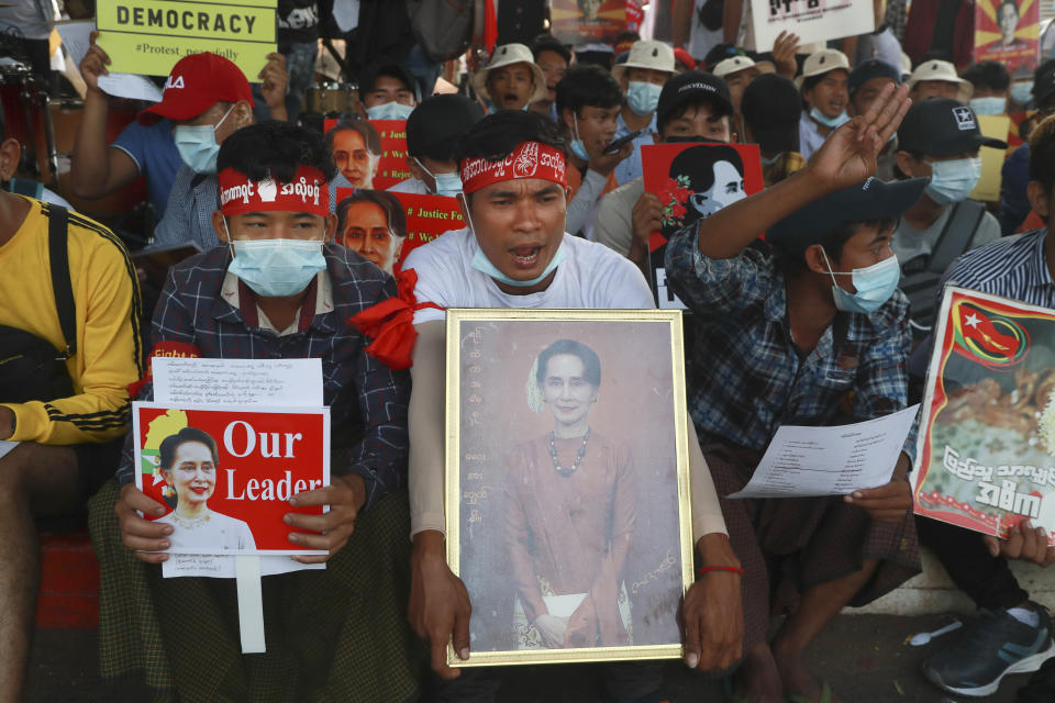 Protesters display images of deposed Myanmar leader Aung San Suu Kyi as they take part in a demonstration against the military coup in Yangon, Myanmar, Friday, Feb. 26, 2021. Security forces in Myanmar's largest city on Friday fired warning shots and beat truncheons against their shields while moving to disperse more than 1,000 anti-coup protesters. (AP Photo)