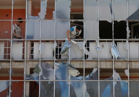 An Afghan man removes fragments of glass from a building after a suicide attack in Kabul, Afghanistan July 24, 2017. REUTERS/Mohammad Ismail