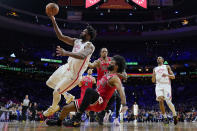 Philadelphia 76ers' Joel Embiid, left, goes up for a shot against Chicago Bulls' Coby White during the second half of an NBA basketball game, Monday, March 20, 2023, in Philadelphia. (AP Photo/Matt Slocum)