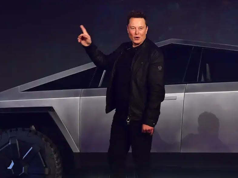 elon musk in front of a cyber truck