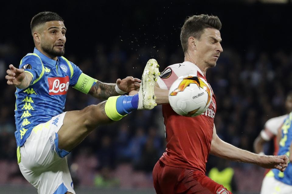 Lorenzo Insigne, izquierda, del Napoli, disputa el balón ante Laurent Koscielny, del Arsenal, en el juego de vuelta de los cuartos de final de la Liga Europa en el estadio San Paolo de Nápoles, Italia, el jueves 18 de abril de 2019. (AP Foto/Luca Bruno)