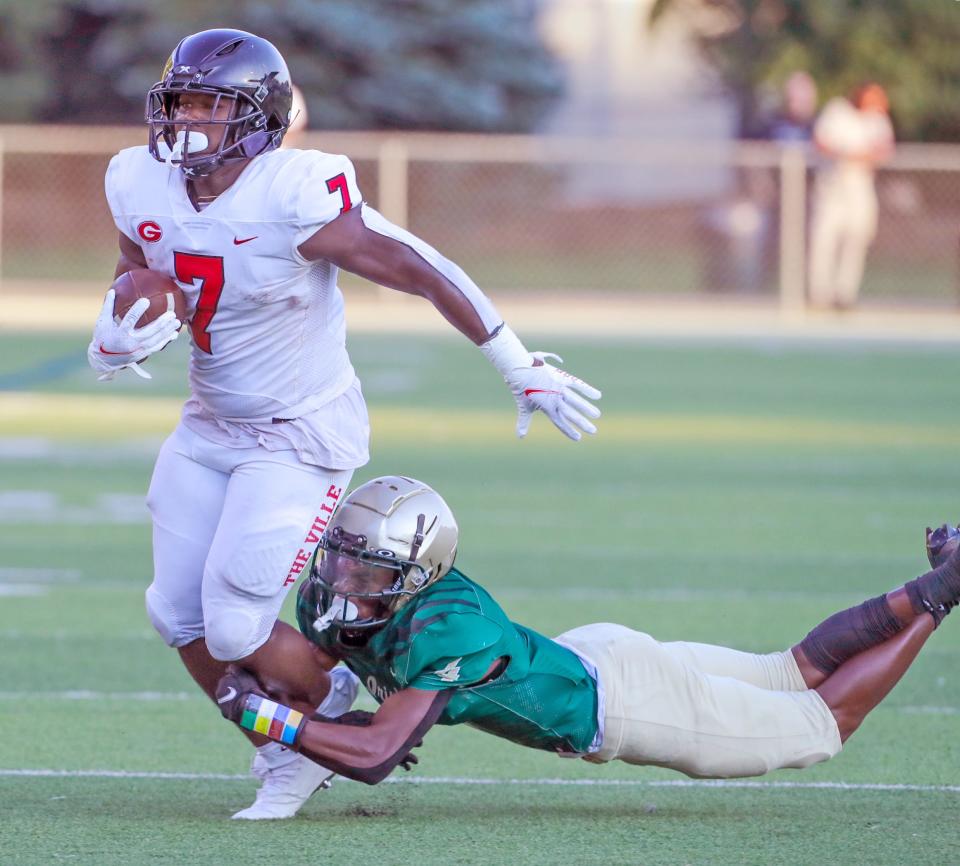 St. Vincent-St. Mary Torell Hopson III takes down Glenville running back D'Shawntae Jones during a first quarter run on Thursday, Aug. 18, 2022 in Akron, Ohio, at John Cistone Field.