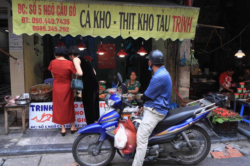 People shop for food in a market in Hanoi, Vietnam on Sunday, Aug. 14, 2022. In the six months since Russia invaded Ukraine, the fallout from the war has had huge effects on the global economy. Though intertwined with other forces, the war has made problems like inflation much worse for people around the world. Soaring food and energy prices have turned into crises that are threatening to plunge millions of people into poverty and make recessions ever more likely. (AP Photo/Hau Dinh)