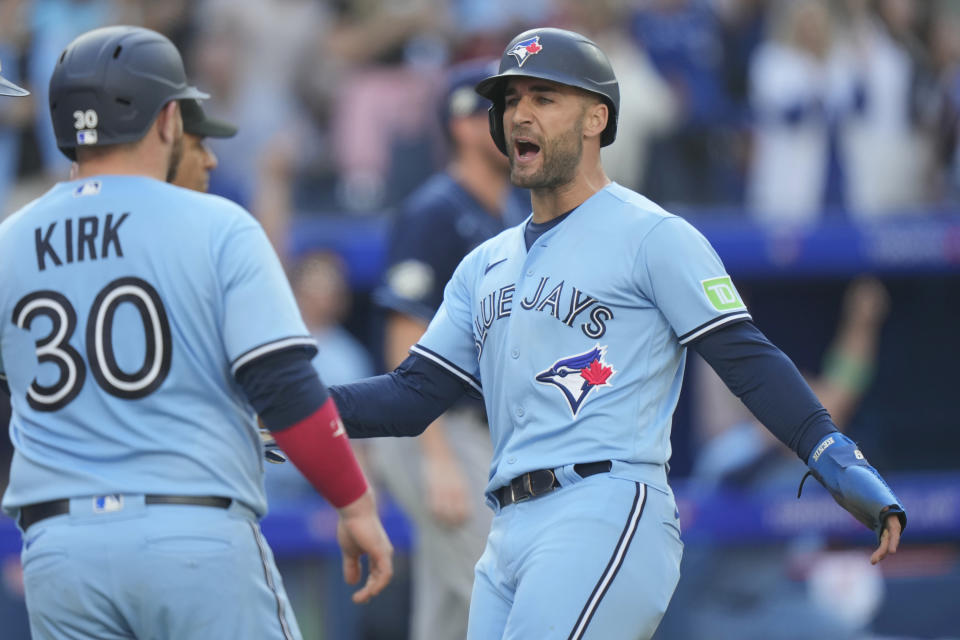 Toronto Blue Jays center fielder Kevin Kiermaier (39) celebrates with teammate Alejandro Kirk (30) after scoring during fourth inning of baseball game against the Tampa Bay Rays in Toronto, Saturday, Sept. 30, 2023. (Frank Gunn/The Canadian Press via AP)