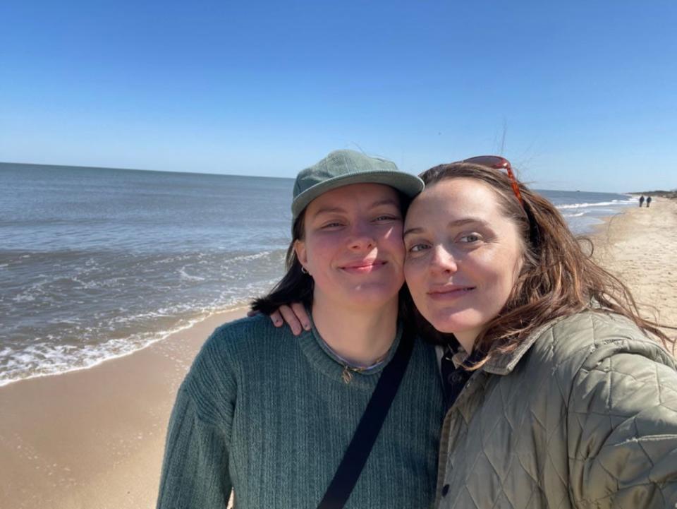 Grace and her partner smiling on the beach