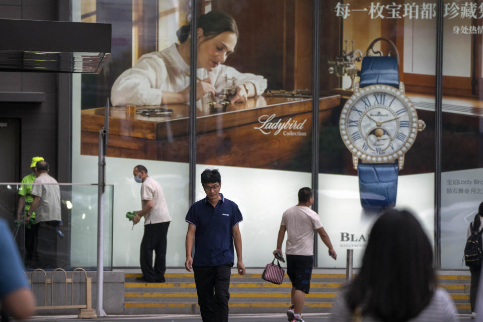 People walk past a billboard for Swiss luxury watch retailer Blancpain at an upscale shopping mall in Beijing, on June 13, 2023. Foreign companies are shifting investments and their Asian headquarters out of China as confidence plunges following the expansion of an anti-spying law and other challenges, the European Union Chamber of Commerce in China said Wednesday, June 21, 2023. (AP Photo/Mark Schiefelbein)
