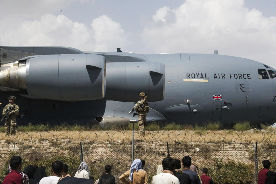 In this handout photo provided by the Ministry of Defence, members of the UK Armed Forces taking part in the evacuation of entitled personnel from Kabul airport in Afghanistan, Friday, Aug. 20, 2021. (LPhot Ben Shread/Ministry of Defence via AP)