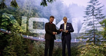 Rajeev Suri (R), Nokia's President and Chief Executive Officer, is greeted by Arto Nummela, Chief Executive Officer of Nokia-HMD, during a ceremony at Mobile World Congress in Barcelona, Spain, February 26, 2017. REUTERS/Paul Hanna