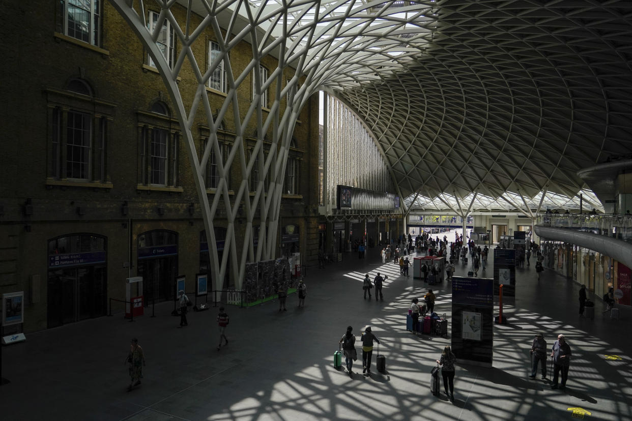 Passengers await their trains to be announced, at a quiet King's Cross station, in London, Tuesday, June 21, 2022. Britain's biggest rail strike in decades went ahead Tuesday after last-minute talks between a union and train companies failed to reach a settlement over pay and job security. Up to 40,000 cleaners, signalers, maintenance workers and station staff are due to walk out for three days this week, on Tuesday, Thursday and Saturday. (AP Photo/Alberto Pezzali)