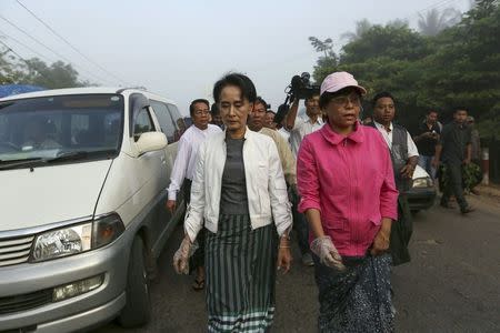 Myanmar pro-democracy leader Aung San Suu Kyi (C) walks as she collects garbage in her constituency Kawhmu township December 13, 2015. REUTERS/Soe Zeya Tun