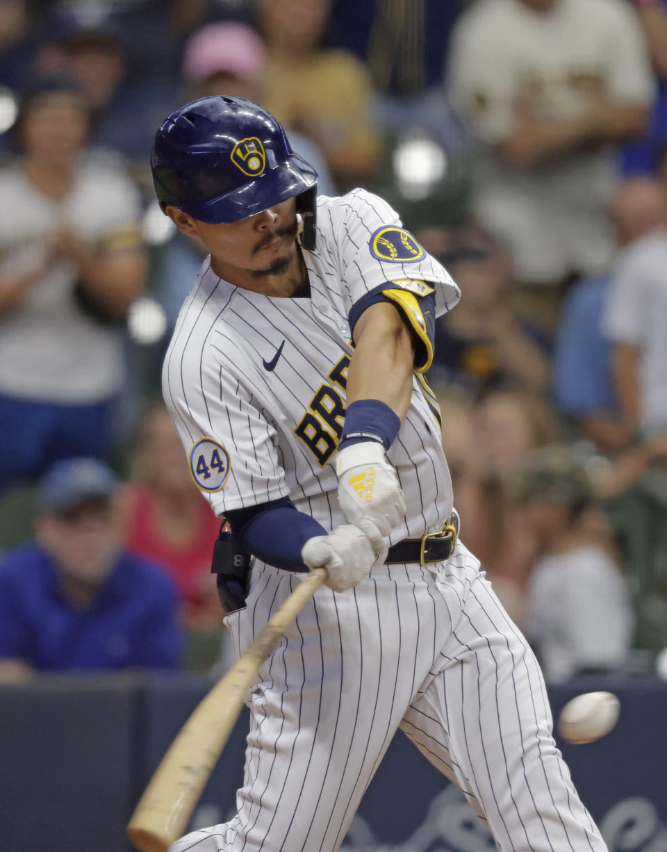 Milwaukee Brewers second baseman Keston Hiura (18) hits a sacrifice fly ball that scored the winning run against the Colorado Rockies during the 11th inning of a baseball game Friday, June 25, 2021, in Milwaukee. (AP Photo/Jeffrey Phelps)