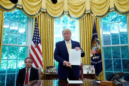 U.S. President Trump holds letter from China's President Xi Jinping during meeting with China's Vice Premier Liu at the White House in Washington