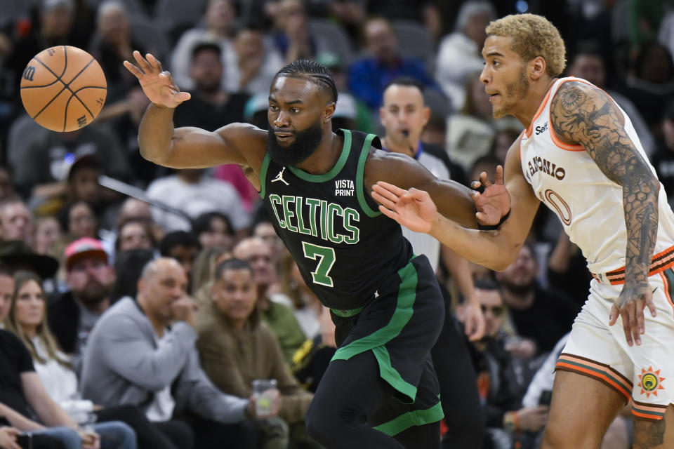 Boston Celtics' Jaylen Brown (7) and San Antonio Spurs' Jeremy Sochan fight for possession during the first half of an NBA basketball game, Sunday, Dec. 31, 2023, in San Antonio. (AP Photo/Darren Abate)