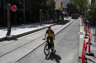 A man rides his bike by an almost empty area of the city following the implementation of stricter social-distancing and self-isolation rules to limit the spread of the coronavirus disease (COVID-19) in Sydney