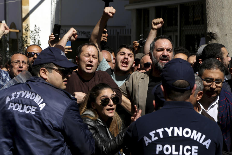 Turkish Cypriot demonstrators shout slogans during a protest against a closed crossing point in the ethnically divided capital Nicosia, Cyprus, Saturday, March 8, 2020. Demonstrators staged another protest against a decision by the Cyprus government to temporarily shut four of nine crossing points along a United Nations controlled buffer zone that separates the south from the breakaway Turkish Cypriot north. The Cypriot government says it shut the crossing points to better check for potential coronavirus carriers. (AP Photo/Petros Karadjias)