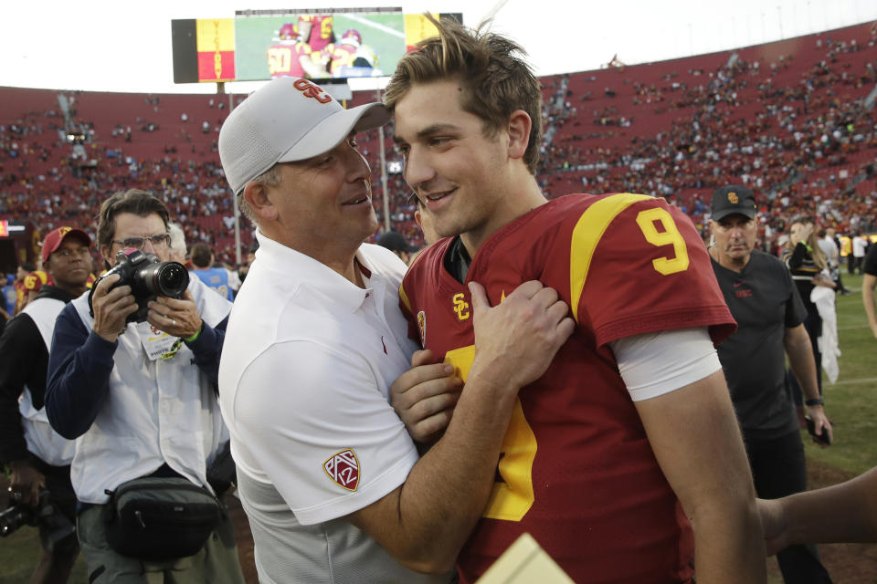 Southern California head coach Clay Helton, left, smiles at quarterback Kedon Slovis (9) after a 52-35 win over UCLA in an NCAA college football game, Saturday, Nov. 23, 2019, in Los Angeles. (AP Photo/Marcio Jose Sanchez)