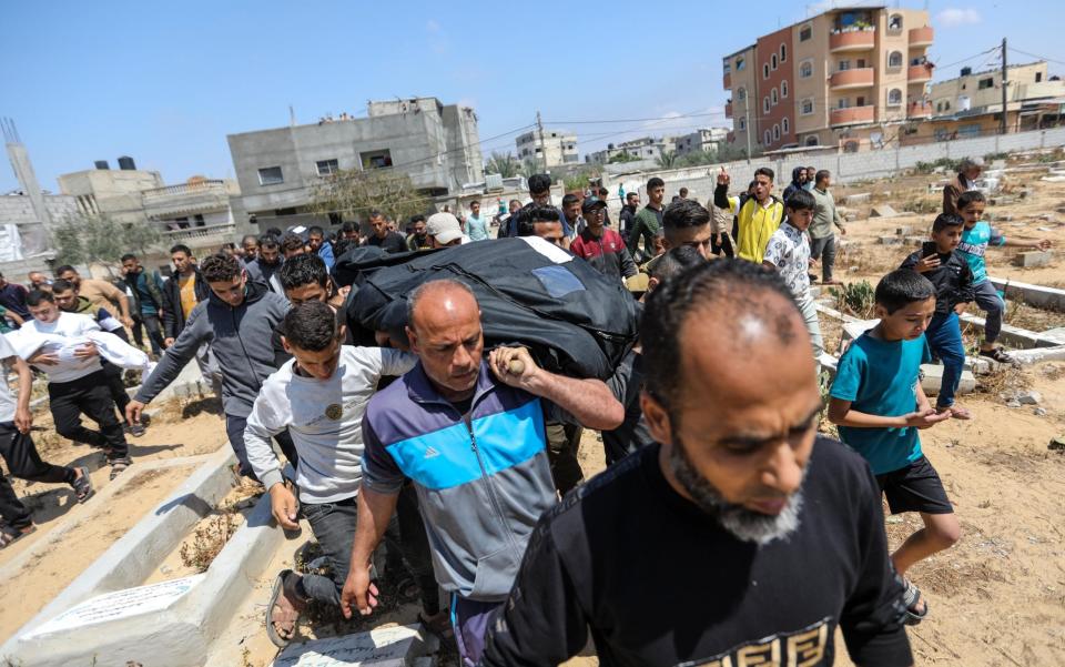 Palestinians mourn as they receive the dead bodies of victims of an Israeli strike