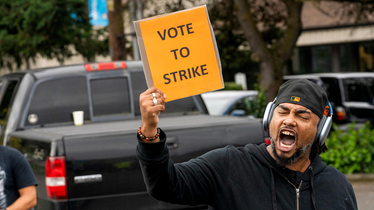 Boeing worker carrying sign saying "vote to strike"