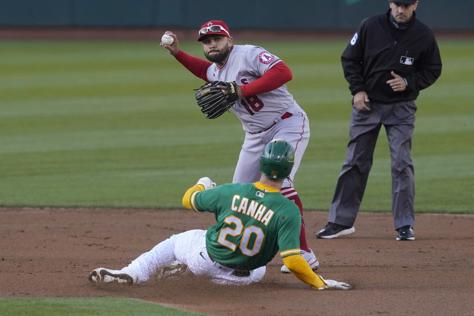 Los Angeles Angels second baseman Jose Rojas, top, throws to first base after forcing out Oakland Athletics' Mark Canha at second base during the first inning of a baseball game in Oakland, Calif., Thursday, May 27, 2021. Ramon Laureano was safe at first. (AP Photo/Jeff Chiu)