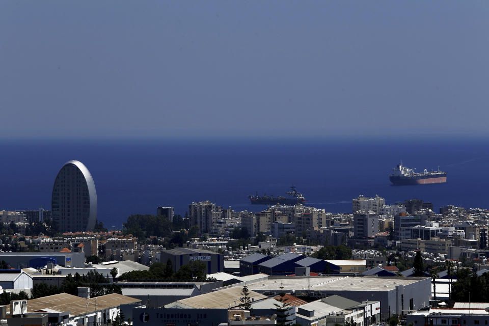 FILE - This Friday, July 6, 2018 file photo, shows the Oval building, left, one of a number of new high-rises transforming the skyline view, of the southern coastal city of Limassol in the eastern Mediterranean island of Cyprus. Cyprus government spokesman Kyriakos Koushos said on Tuesday, Oct. 13, 2020, that the Cabinet accepted a recommendation by the minsters of the interior and finance to cancel altogether the "golden passport" program that has netted billions of euros over several years. Koushos said the decision was based on the Cyprus Investment Program's "long-standing weaknesses, but also the abuse" of its provisions. (AP Photo/Petros Karadjias, File)