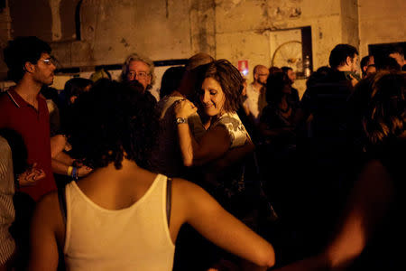 People dance during a party organised by the "Assemblea Cavallerizza 14:45" movement at the Cavallerizza Reale building, which is occupied by the movement in Turin, Italy, July 15, 2016. REUTERS/Marco Bello