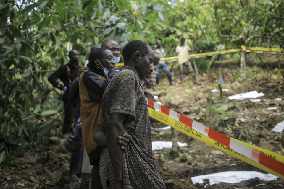 A man looks over the cordon at human remains in a mass grave in the village of Ndoma, near Beni in North Kivu, Congo Saturday, May 6, 2023. The remains of at least 20 people were found buried in a mass grave in an area used to cultivate cacao in Ndoma village in Congo's North Kivu province this weekend, according to local authorities and a military spokesperson. (AP Photo)