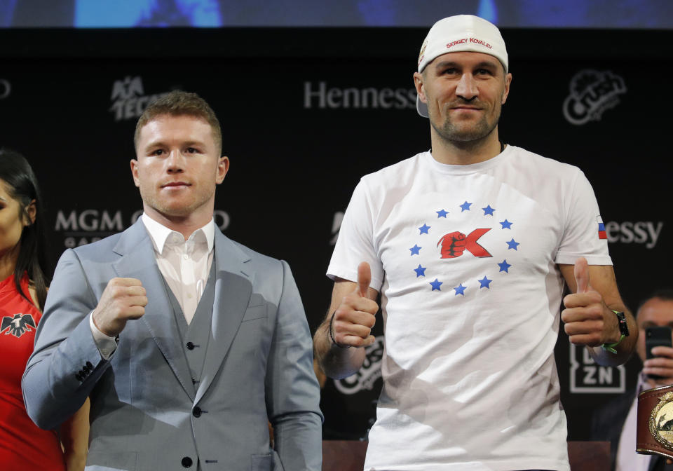 Sergey Kovalev, right, and Canelo Alvarez pose for photographers during a news conference Wednesday, Oct. 30, 2019, in Las Vegas. The two are scheduled to fight in a WBO light heavyweight title bout Saturday in Las Vegas. (AP Photo/John Locher)