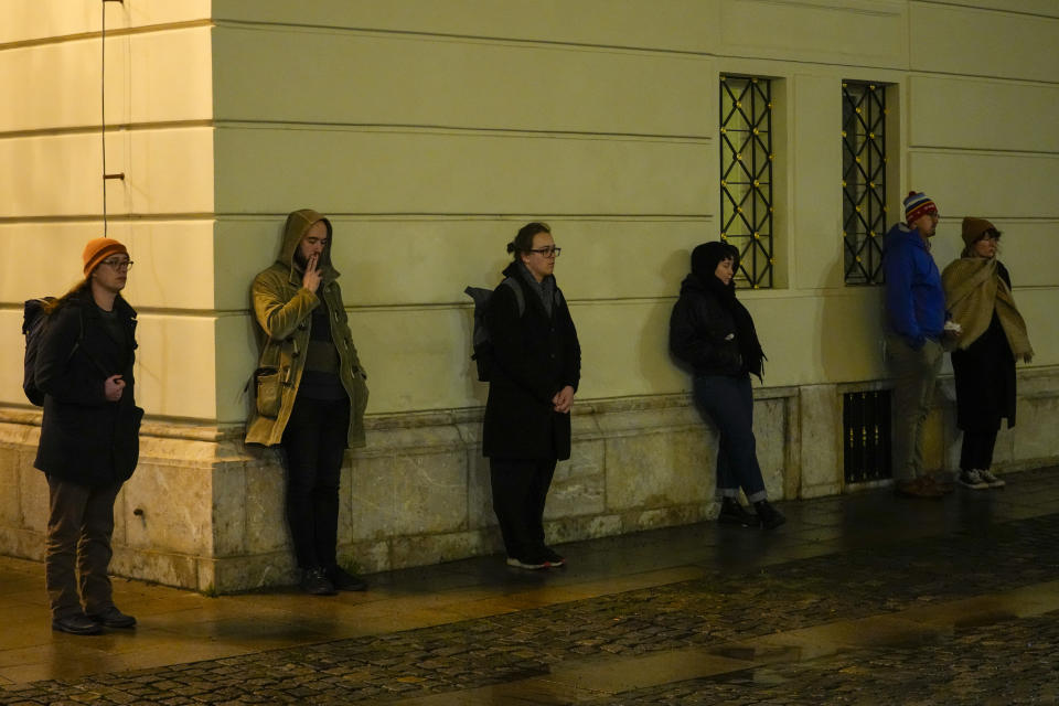 People stand outside the building of Philosophical Faculty of Charles University in downtown Prague, Czech Republic, Thursday, Dec. 21, 2023. A mass shooting in downtown Prague killed several people and injured others, and the person who opened fire also is dead, Czech police and the city's rescue service said Thursday. (AP Photo/Petr David Josek)