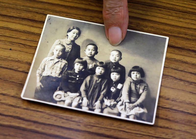 Terumi Tanaka shows his photo during an interview with Reuters in Tokyo