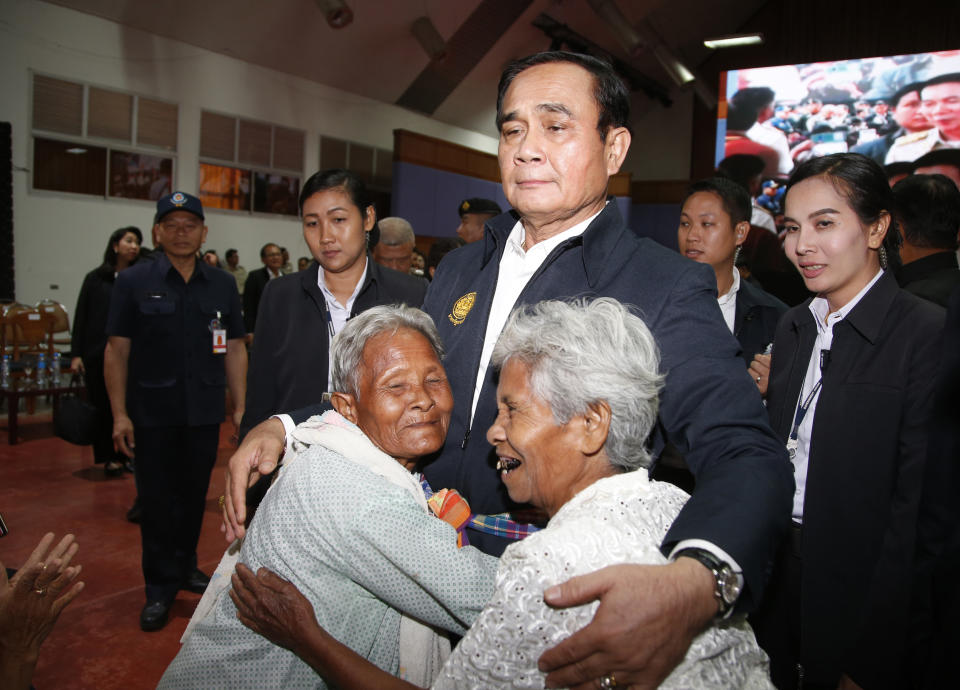 In this March 13, 2019, photo, elderly locals hug Prime Minister Prayuth Chan-ocha and candidate for the same position, as he attends a government-sponsored event in Nakhon Ratchasima, Thailand. Prayuth has been nominated by a pro-army political party to become prime minister again after the March 24 general election. (AP Photo/Sakchai Lalit)