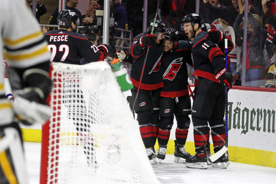 Carolina Hurricanes' Max Domi (13) celebrates hiss goal against the Boston Bruins with Brady Skjei, left, and Jordan Staal (11) during the second period of Game 7 of an NHL hockey Stanley Cup first-round playoff series in Raleigh, N.C., Saturday, May 14, 2022. (AP Photo/Karl B DeBlaker)