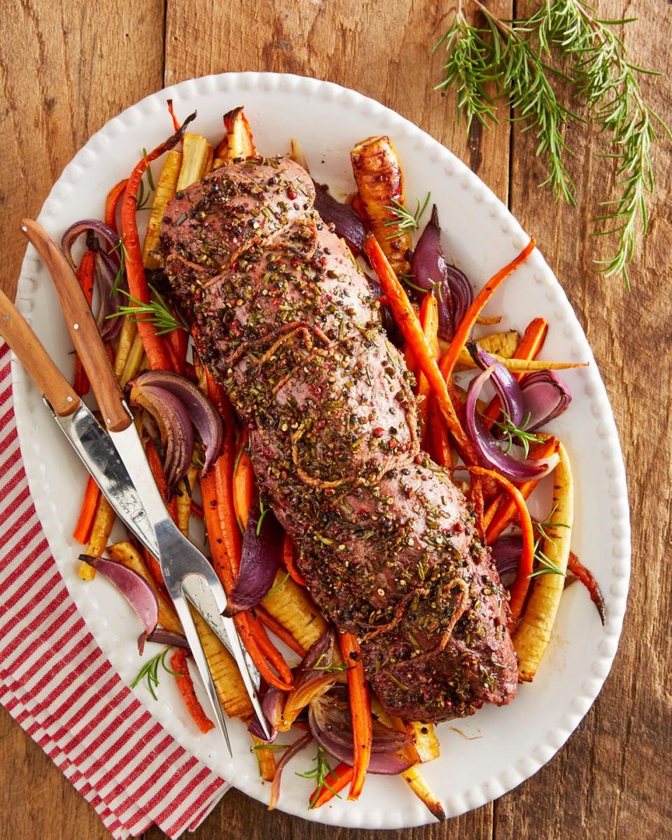 rosemary beef tenderloin with root vegetables on an oval white serving plate