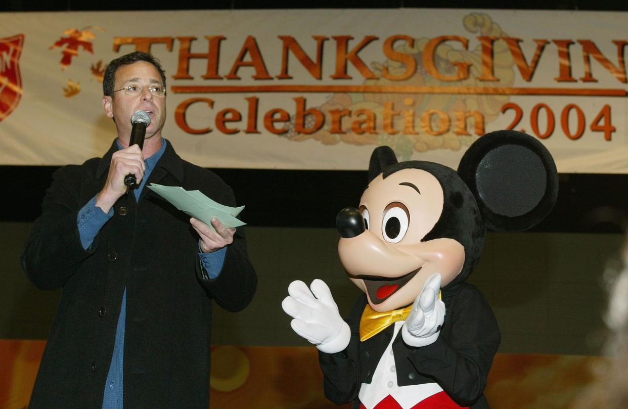 Comedian/host Bob Saget and Mickey Mouse perform during the "The Salvation Army/Disneyland Thanksgiving Eve Dinner" at the Los Angeles Convention Center on Nov. 24, 2004, in Los Angeles, Calif.