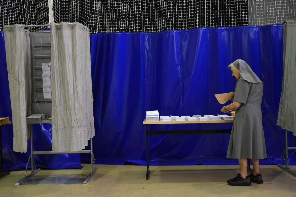 A nun picks her ballots before voting at a polling station in Pamplona, Spain, Sunday July 23, 2023. Polling began Sunday in Spain in a general election that could make the country the latest European Union member to swing to the political right.(AP Photo/Alvaro Barrientos)