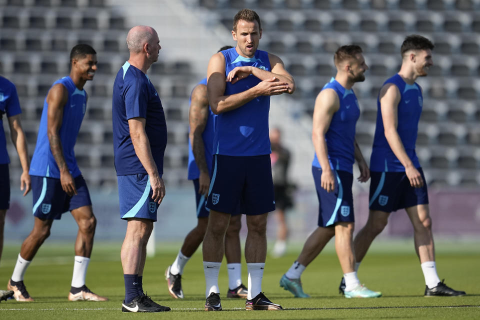 England's Harry Kane, middle, stands on the field during England's official training on the eve of the group B World Cup soccer match between England and the United States, at Al Wakrah Sports Complex, in Al Wakrah, Qatar, Thursday, Nov. 24, 2022. (AP Photo/Abbie Parr)