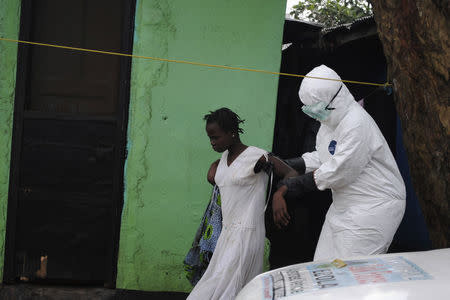 A health worker brings a woman suspected of having contracted the Ebola virus to an ambulance in Monrovia, Liberia, September 15, 2014. REUTERS/James Giahyue